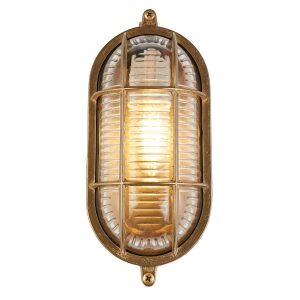 Solid brass oval outdoor bulkhead light with ribbed glass shade vertical on white background lit