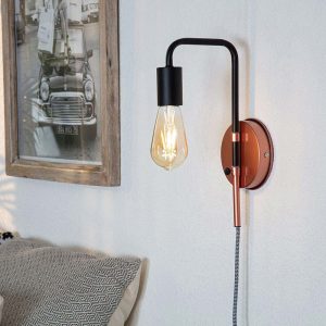 Steampunk plug in wall light in matte black and metallic copper on lounge wall