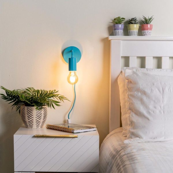 Plug in wall light in Capri blue shown lit on bedroom wall