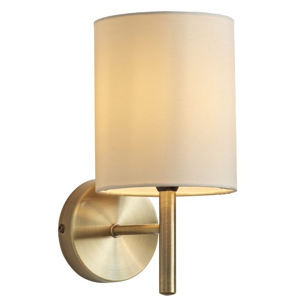 Brio 1 light antique brass wall light with cream shade on white background, lit.