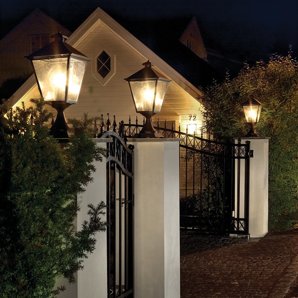 Trio of illuminated post lights outside home at night