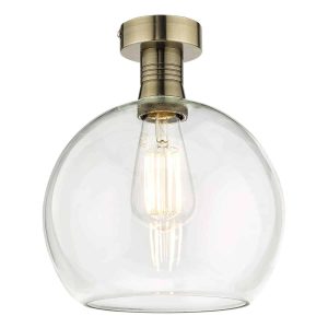 Emerson low ceiling light in antique brass with clear glass globe shade on white background