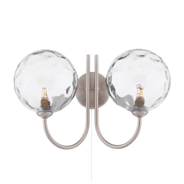 Jared twin switched wall light in satin nickel with dimpled clear glass shades on white background lit