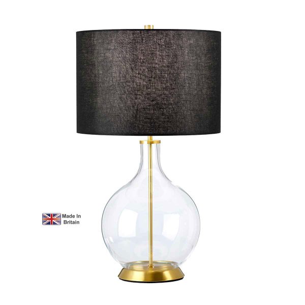 Elstead Orb clear glass table lamp in antique brass with black shade on white background, lit.